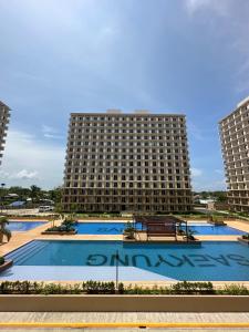 a large building with a large pool in front of it at Lapu-Lapu City Condo in Lapu Lapu City