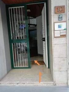 an open door of a building with an orange arrow pointing to the entrance at Case vacanze Monroe 1 in Palermo