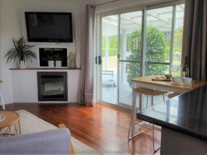 a living room with a table and a tv on the wall at Delaware Retreat in Mount Panorama +22 photos