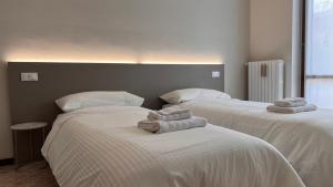 2 posti letto in camera con asciugamani di Charme & Comfort in Franciacorta a Rodengo Saiano