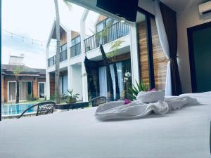 a bed with towels on it in front of a building at Tuong Vy Boutique Hotel Mui Ne in Mui Ne