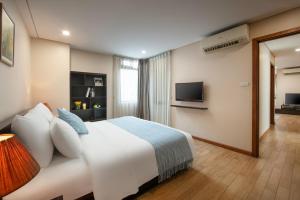 ein Hotelzimmer mit einem Bett und einem TV in der Unterkunft HB Serviced Apartment - 121B Quan Hoa in Hanoi