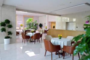 uma sala de jantar com mesas e cadeiras num restaurante em Beijing CSN Pearl Hotel em Pequim