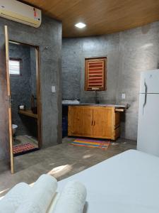 a room with a kitchen with a sink and a refrigerator at Chalé Rj Rio in Santo Amaro