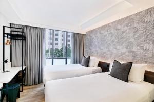 מיטה או מיטות בחדר ב-Kith Hotel Darling Harbour