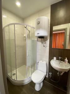 uma casa de banho com um chuveiro, um WC e um lavatório. em Mini-hotel in Odessa Yard em Odessa