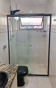 uma casa de banho com uma cabina de duche em vidro e um WC. em Locação Temporada Cabo Frio RJ. em Cabo Frio