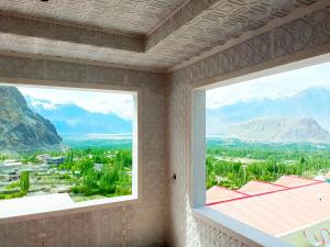 duas janelas num quarto com vista para as montanhas em Hotel Mountain Lodge Skardu em Skardu