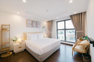 Love St - Hanoi Hotel في هانوي: غرفة نوم بسرير ابيض ونافذة كبيرة