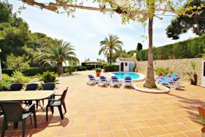 a patio with chairs and a table and a pool at Finca Coello - charming, Spanish finca style holiday villa in Benissa in Benissa