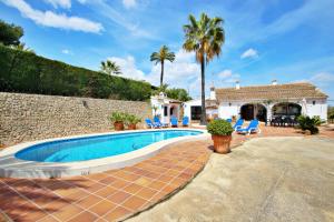 a swimming pool with chairs and a house at Finca Coello - charming, Spanish finca style holiday villa in Benissa in Benissa
