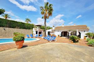 a villa with a swimming pool and lounge chairs at Finca Coello - charming, Spanish finca style holiday villa in Benissa in Benissa