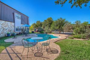 a patio with a table and chairs next to a pool at SS 6B Teckelhaus in New Braunfels