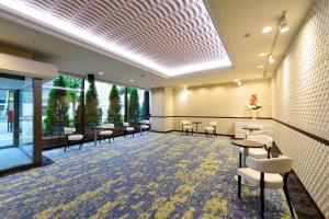 una sala d'attesa con sedie, tavoli e finestre di Ginza Capital Hotel Akane a Tokyo