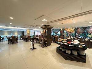 a restaurant with tables and chairs and a buffet at Northern Saigon Hotel in Ho Chi Minh City