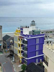 a purple building with the ocean in the background at 七星潭燈塔海景民宿 in Dahan