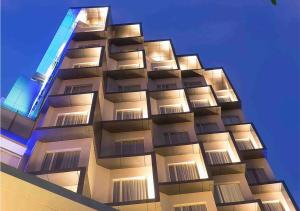 um edifício alto com luzes em cima em Holiday Inn Express Jakarta Wahid Hasyim, an IHG Hotel em Jakarta