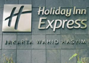 un cartello per la Hilley Inn Express su un edificio di Holiday Inn Express Jakarta Wahid Hasyim, an IHG Hotel a Giacarta