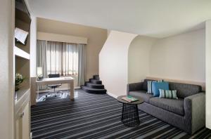 a living room with a couch and a desk at DoubleTree by Hilton Esplanade Darwin in Darwin