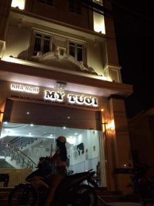 a woman sitting on a motorcycle in front of a shop at Mỹ Tươi Hotel PQ - by BAY LUXURY in Phu Quoc