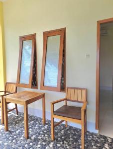 スンギギにあるKJ Inn Homestay Senggigiの鏡2つ付きの部屋(テーブル2台、椅子1脚付)