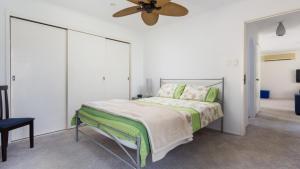 a bedroom with a bed and a ceiling fan at Beachcomber in Old Bar