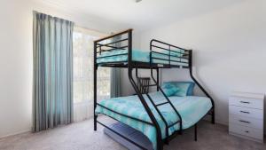 a bedroom with two bunk beds and a window at Beachcomber in Old Bar