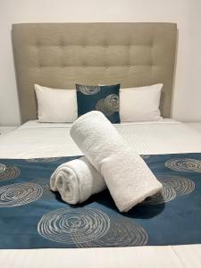 a white towel laying on top of a bed at Direct Collective - Pavilion and Governor on Brookes in Brisbane