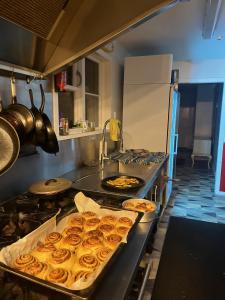 Hekerua Lodge Backpackers Hostel Waiheke Island في Oneroa: مطبخ مع عدة صواني من الكعك على منضدة