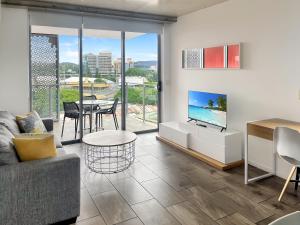 een woonkamer met een bank, een tv en een tafel bij Direct Collective - Pavilion and Governor on Brookes in Brisbane