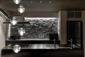 - une cuisine avec un évier et un mur en briques dans l'établissement HOTEL MASTAY jingumichi, à Kyoto
