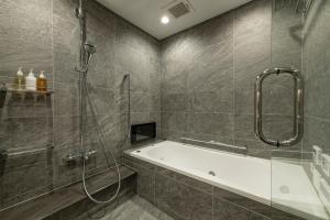 La salle de bains est pourvue d'une douche et d'une baignoire. dans l'établissement HOTEL MASTAY jingumichi, à Kyoto