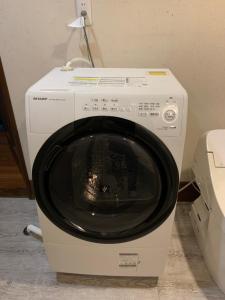 a white washing machine in a room with a lamp at Hakuba Ski Condos in Hakuba