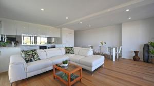a living room with a white couch and a table at Sea Breeze in Old Bar