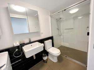 uma casa de banho com um lavatório, um WC e um chuveiro em Direct Collective - Pavilion and Governor on Brookes em Brisbane