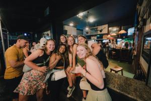 Un gruppo di persone che posano per una foto in un bar di Howzit Hostels Hawaii a Hilo