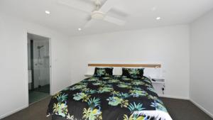 a bedroom with a bed and a ceiling fan at Sea Breeze in Old Bar +9 photos