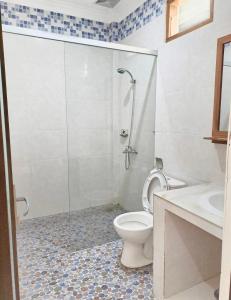 a bathroom with a shower and a toilet and a sink at KJ Inn Homestay Senggigi in Senggigi 