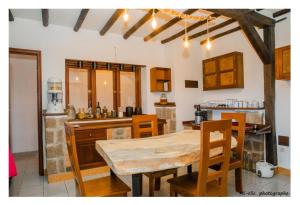 a kitchen with a wooden table and chairs in a room at MANGA BLUE'S GUEST HOUSE in Fianarantsoa