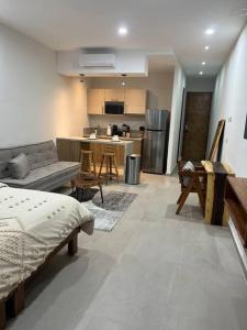a living room with a couch and a kitchen at Solum Luxury Condos in Tulum