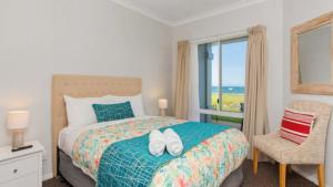 a bedroom with a bed with two white shoes on it at Apartment 14 - The Meridian in Old Bar