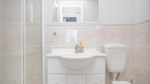 a white bathroom with a sink and a toilet at Apartment 14 - The Meridian in Old Bar +10 photos
