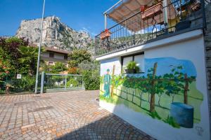 ein Gebäude mit Wandgemälde mit einem Berg im Hintergrund in der Unterkunft Casa Del Sole Apartments - Happy Rentals in Arco