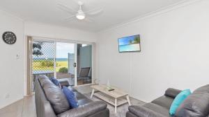 a living room with a couch and a table at Apartment 19 - The Meridian in Old Bar