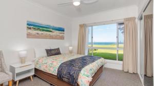 a bedroom with a bed and a large window at Apartment 19 - The Meridian in Old Bar +10 photos