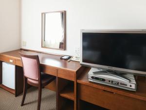 a room with a desk with a television and a chair at Vessel Hotel Fukuoka Kaizuka in Fukuoka