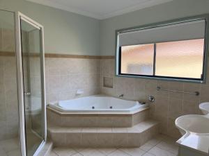 ein Badezimmer mit Badewanne und Waschbecken in der Unterkunft Cooloola Cottage Rainbow Beach in Rainbow Beach + 7 Fotos