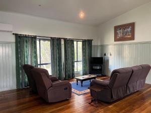 ein Wohnzimmer mit zwei Stühlen und einem Tisch in der Unterkunft Cooloola Cottage Rainbow Beach in Rainbow Beach