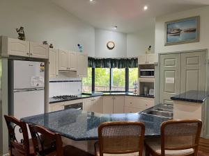 eine Küche mit weißen Schränken und einer blauen Arbeitsplatte in der Unterkunft Cooloola Cottage Rainbow Beach in Rainbow Beach