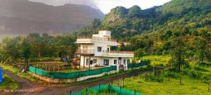a house in the middle of a mountain at Shri Bhuvaneshvari Homestay in Karjat
